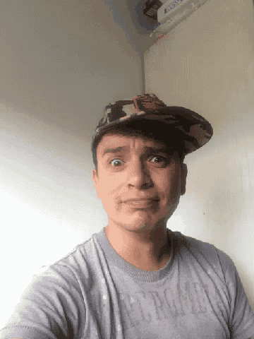 a man wearing a hat and a gray shirt with the word abercrombie on it
