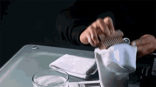 a person is brushing their hair with a wooden comb