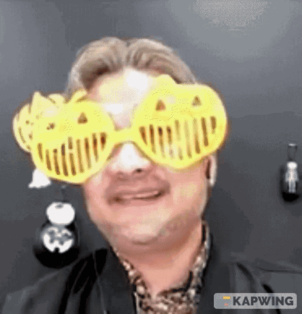 a man wearing a pair of yellow halloween glasses with pumpkins on them