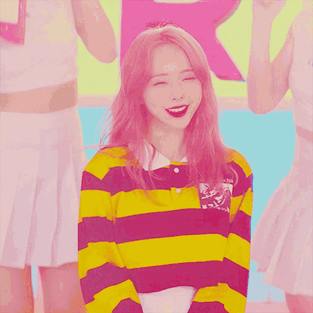a girl with pink hair wearing a yellow and red striped shirt that says cute