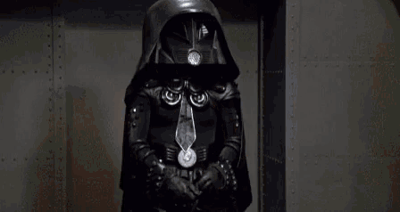 a man in a leather jacket is holding a light saber in front of a button that says button unless you really mean it .
