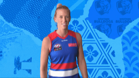 a woman wearing a western bulldogs jersey makes a funny face