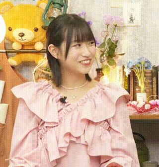 a girl in a pink dress is smiling in front of a stuffed teddy bear .
