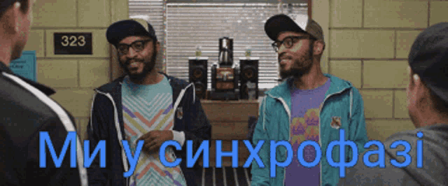 two men are standing in front of a sign that says 323 on it