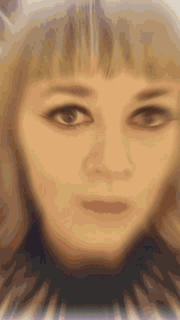 a close up of a woman 's face with a blurred background and a red lip