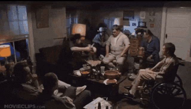 a group of people are gathered around a table with movieclips.com written on the bottom