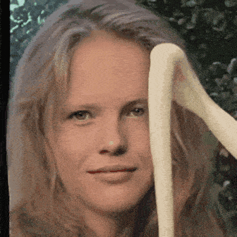 a close up of a woman 's face with a snake coming out of her hair