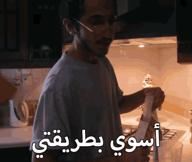 a man standing in a kitchen with arabic writing on it