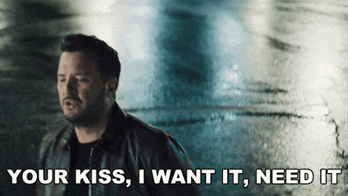 a man says " your kiss i want it need it " in a dark room