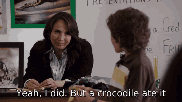 a woman sits at a desk with a boy and says " yeah i did but a crocodile ate it