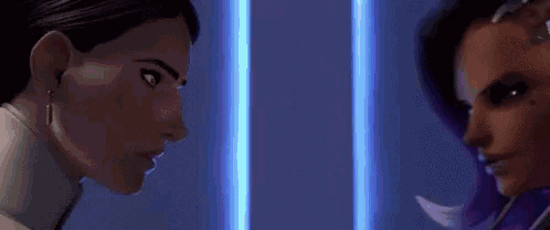 two women are standing next to each other in a room and looking at each other .
