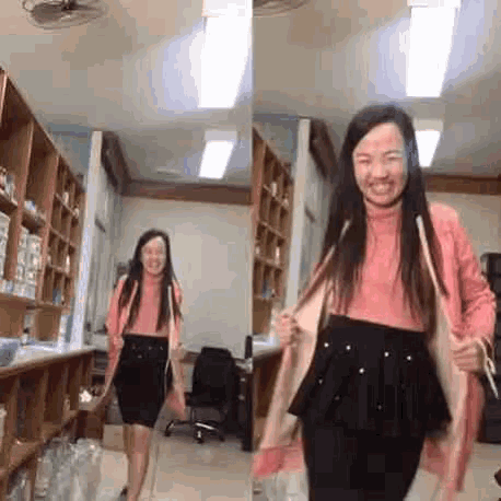 a woman in a pink sweater and black skirt is standing in a room with a fan .