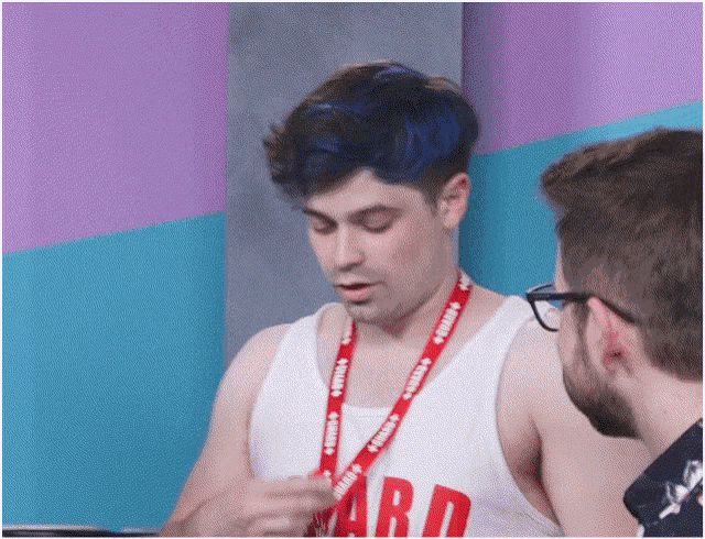 a man with blue hair has a lanyard around his neck that says " squad "