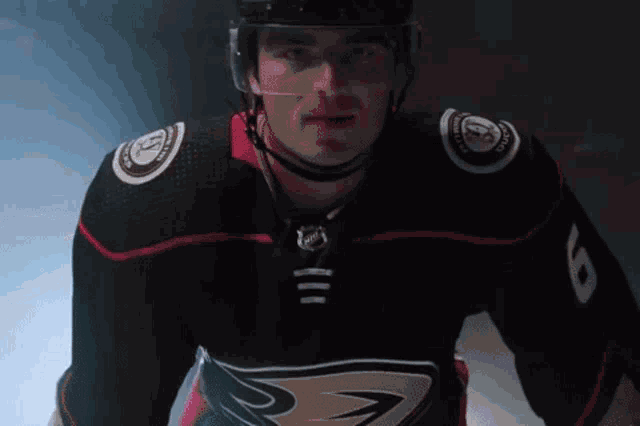 a hockey player wearing a black jersey with the number 8 on the sleeve