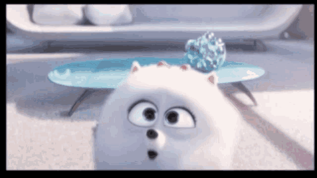 a cartoon dog with a pom pom on its head is looking at the camera .