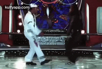 a man and a woman are dancing on a stage on a dance floor .