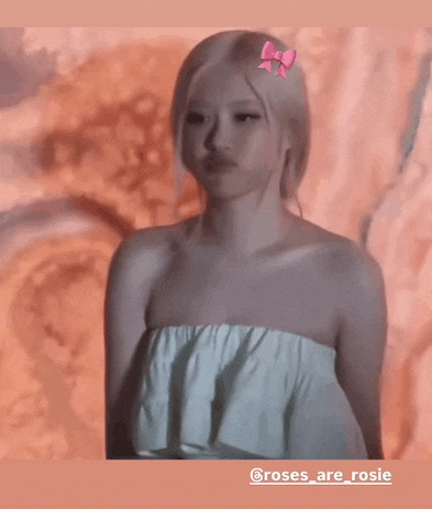 a woman with a pink bow in her hair is wearing a white strapless top