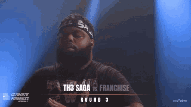 a man wearing a headband with the word saga on it is standing in front of a sign that says th3 saga vs franchise round 3