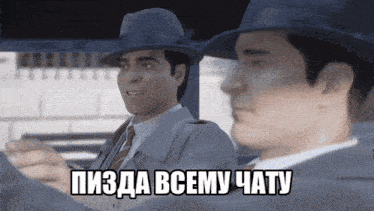two men in suits and hats are sitting next to each other and one of them says пизда всему чату