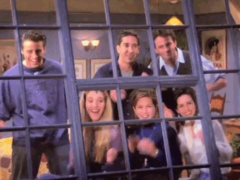 a group of people are standing in front of a window looking out .