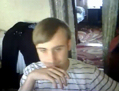 a man in a striped shirt is sitting in a room