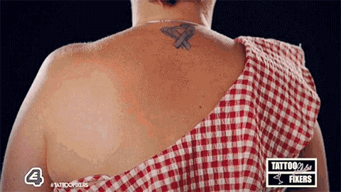 a woman with a tattoo on her back is wearing a red plaid shirt .