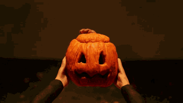 a carved pumpkin with a scary face is lit up at night
