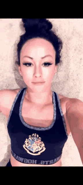 a woman is taking a selfie with her arms outstretched in a black sports bra .