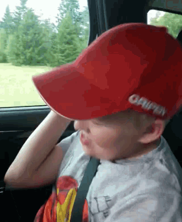 a young boy wearing a red hat that says gripper