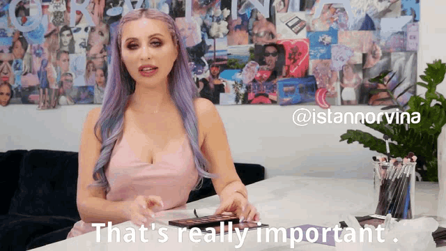 a woman with purple hair says " that 's really important " in front of a wall of pictures