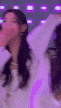 a woman is dancing in front of a purple background .