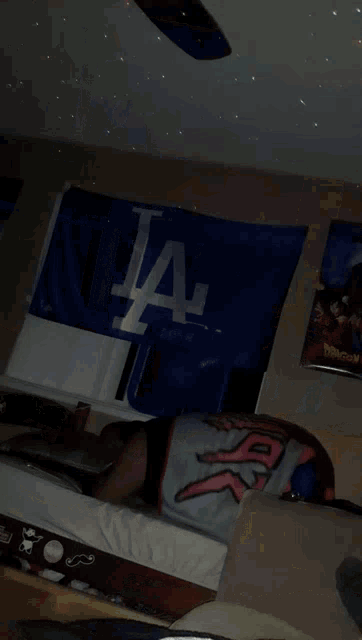 a man laying on a bed in front of a la banner