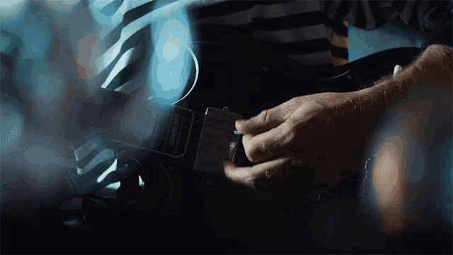 a close up of a person playing a guitar that says ' fender ' on the neck