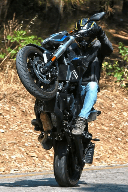 a man riding a motorcycle with a yamaha helmet on