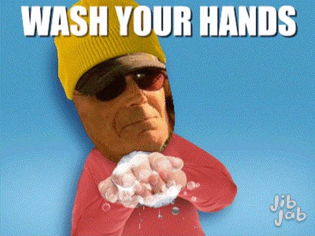 a man wearing a yellow beanie and sunglasses is washing his hands