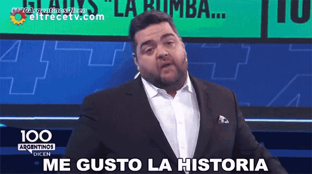 a man in a suit says me gusto la historia on a television screen