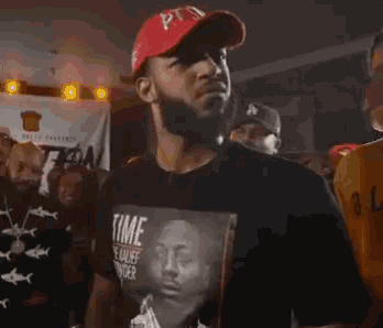 a man wearing a red hat and a black shirt that says time on it