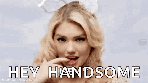 a woman wearing bunny ears is licking her lips and saying `` hey handsome '' .