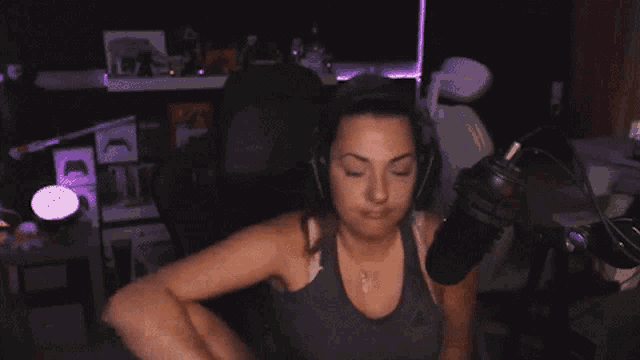 a woman wearing headphones is sitting in front of a microphone with a ring on her finger