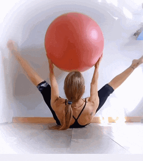 a woman holds a red ball over her head