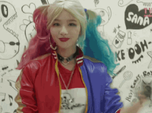 a woman in a harley quinn costume is standing in front of a wall with drawings on it and says ke ooh