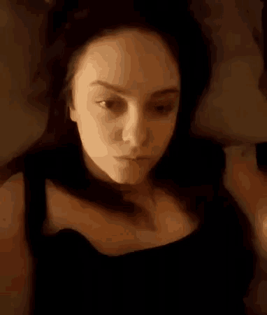 a woman is laying on a bed with her eyes closed and her mouth open .