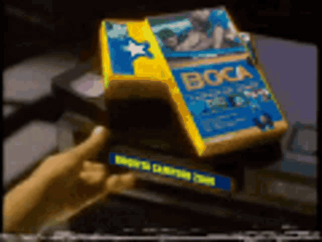 a person is holding a box that says boca