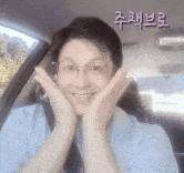 a woman in a car with her hands on her face .