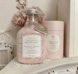 a bottle of bath salt next to a pink can
