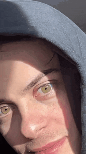 a close up of a person 's face with a hood on