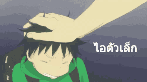 a hand touching a child 's forehead with a foreign language written on the bottom