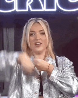 a woman in a silver jacket is making a funny face .