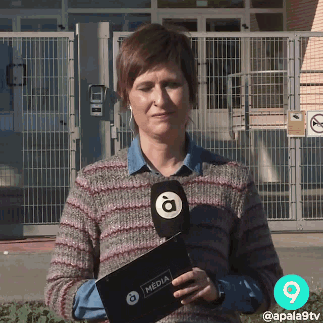 a woman holding a microphone with the word media on it