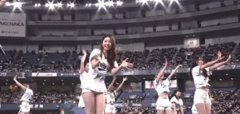 a group of cheerleaders are performing in front of a crowd in a stadium with an ad for akenaka in the background